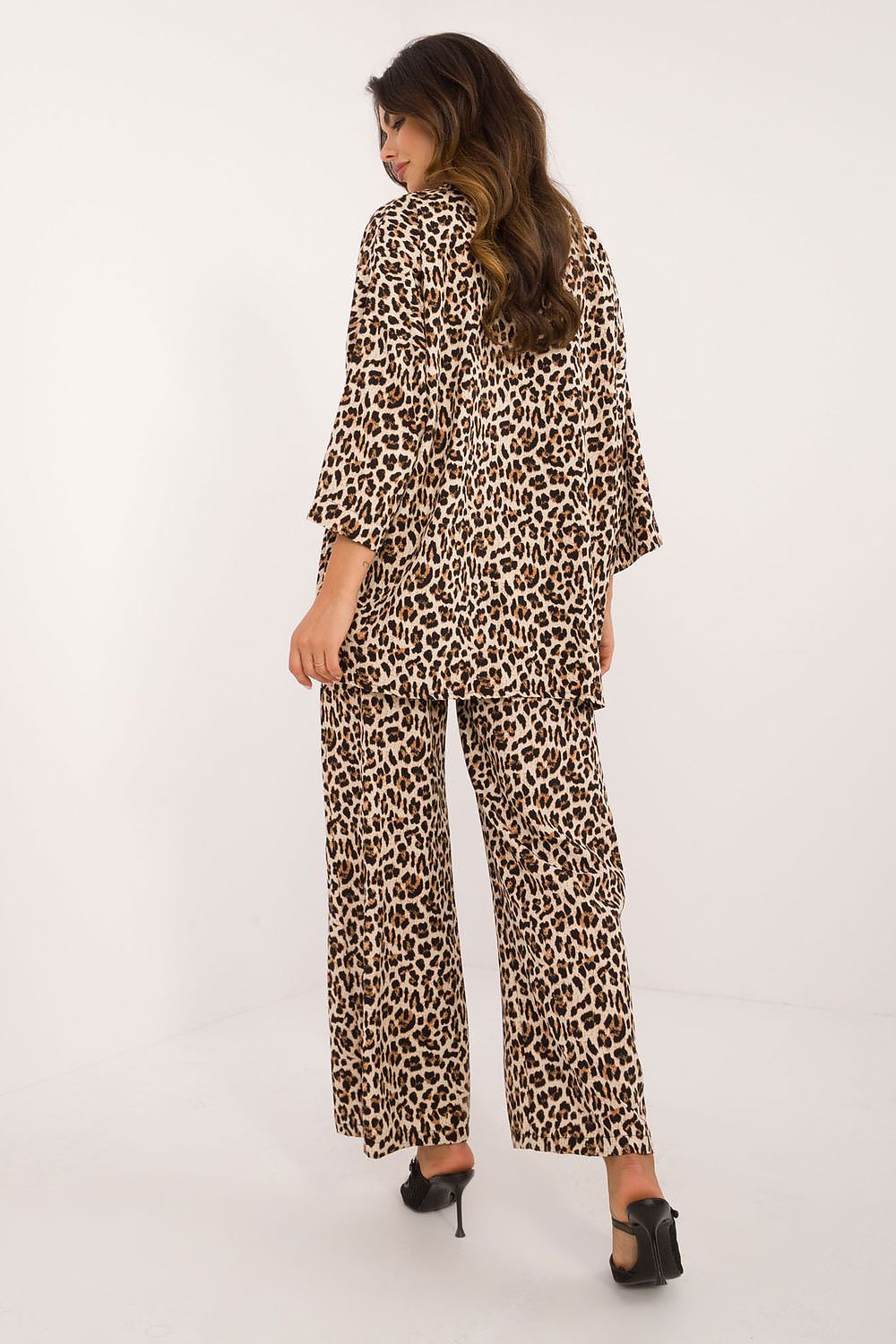 Close-up of Italy Moda's luxury casual wear, highlighting the animal print design on the buttoned shirt and the comfortable fit of the high-waist trousers.