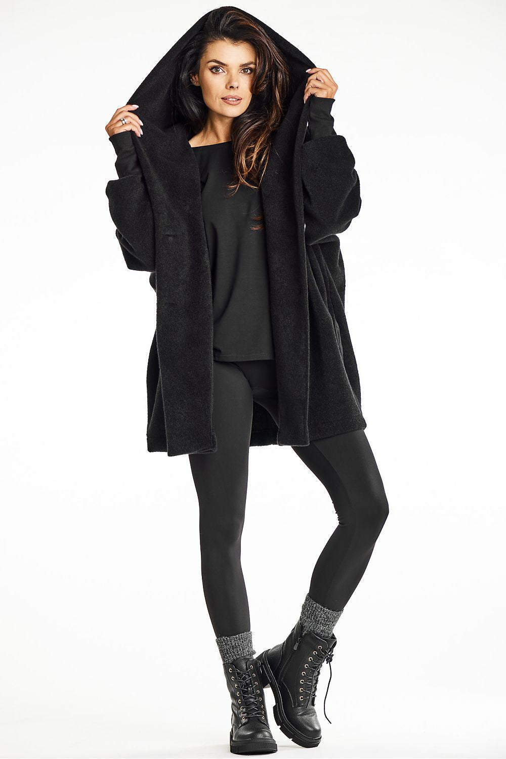 Model wearing the elegant black hooded kimono coat by Awama, paired with cowboy boots, perfect for colder days.
