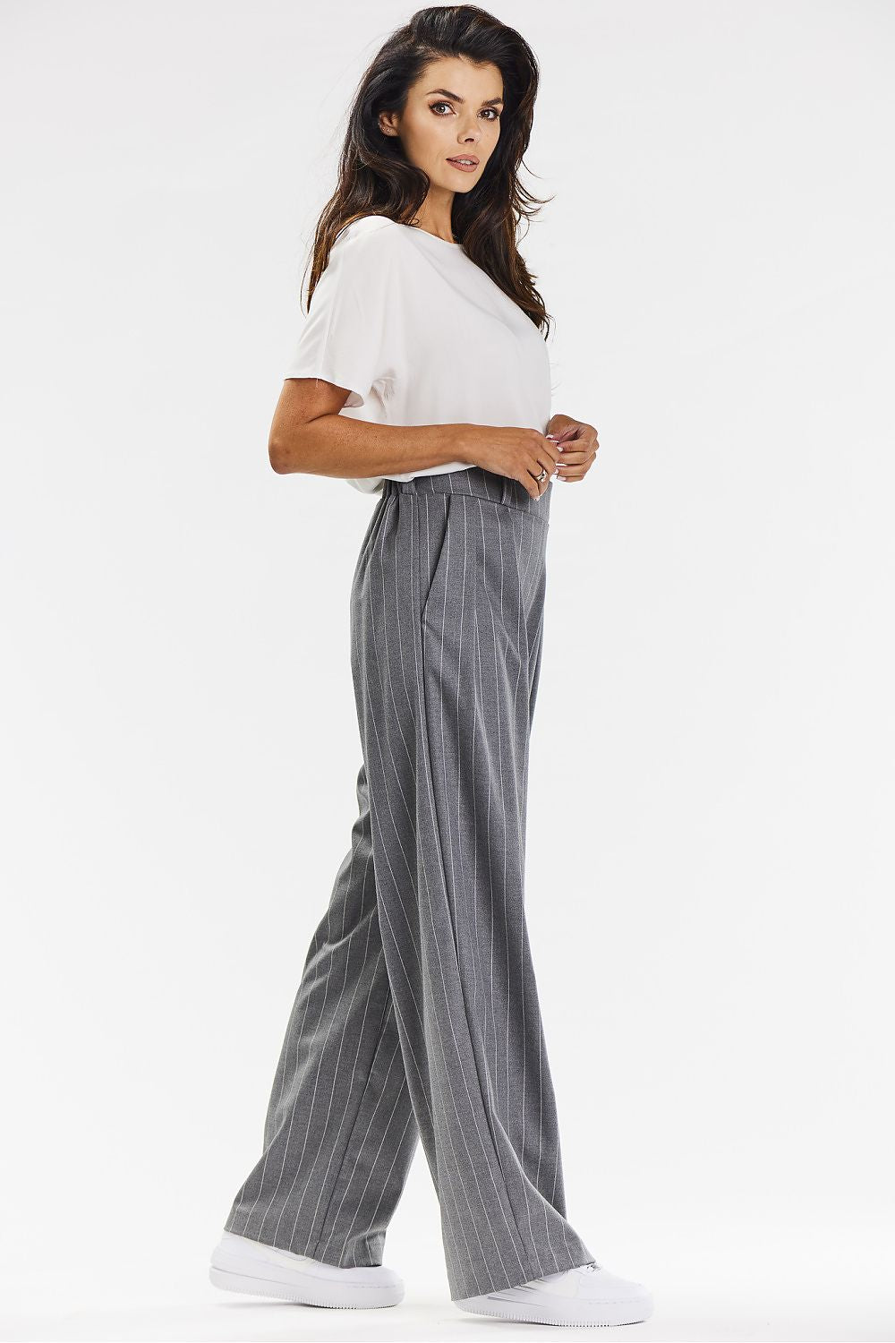 Elegant full-length view of Awama's wide-leg trousers in grey with white stripe, displaying modern ribbed pattern for sophisticated outfits.