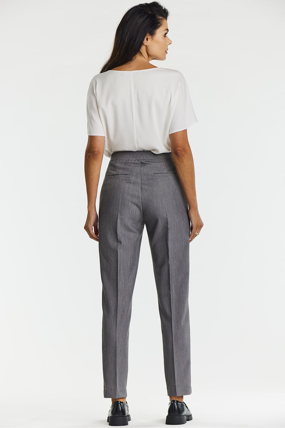 Model wearing Awama's elegant gray canted cigarette trousers, paired with a chic top, demonstrating the trousers' versatile styling for various occasions.