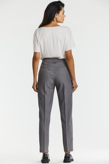Model wearing Awama's elegant gray canted cigarette trousers, paired with a chic top, demonstrating the trousers' versatile styling for various occasions.