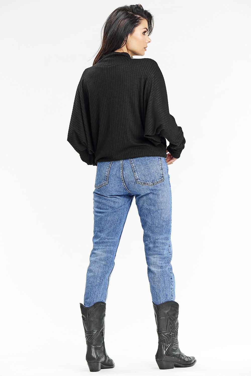 Model wearing the Awama black ribbed turtleneck sweater with kimono sleeves, embodying elegance and comfort in a casual autumn setting.