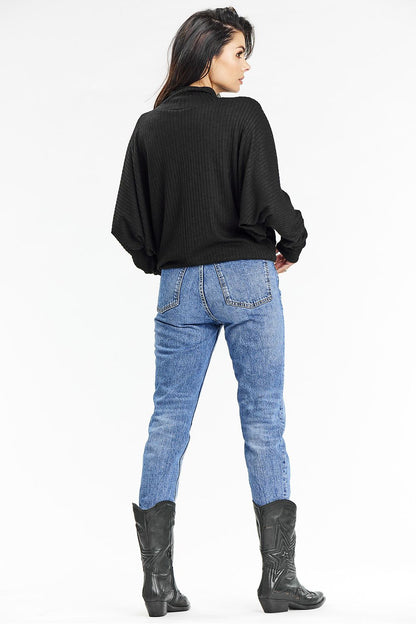 Model wearing the Awama black ribbed turtleneck sweater with kimono sleeves, embodying elegance and comfort in a casual autumn setting.