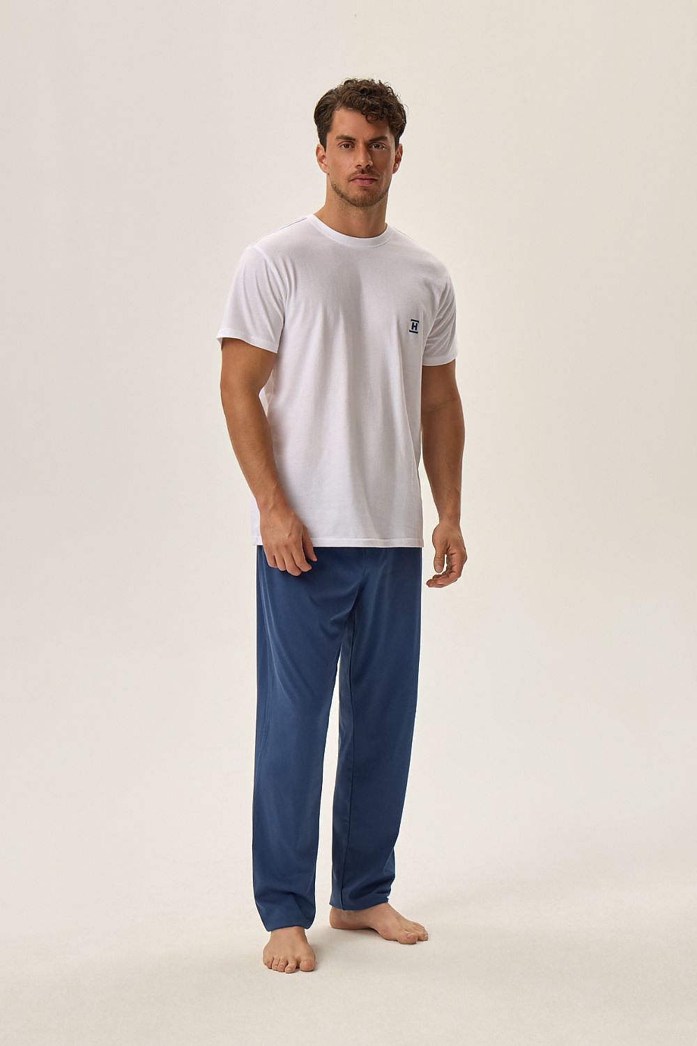 Henderson Cotton Pyjama Set featuring a stylish white T-shirt with the brand logo, complemented by luxurious blue pants with an elastic waistband, representing comfort and elegance.