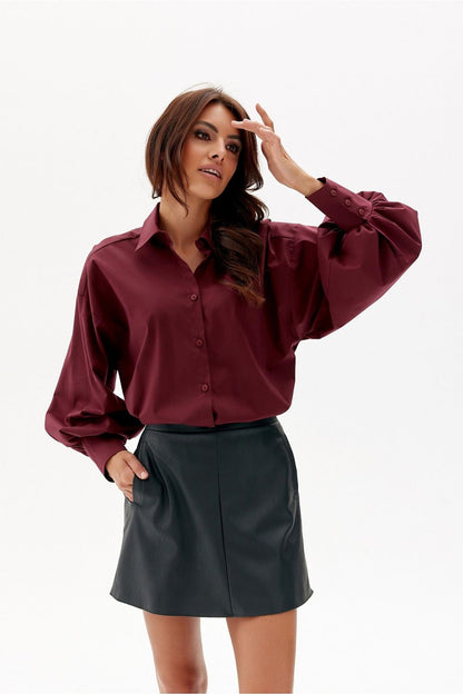 Fashion-forward autumn-winter outfit featuring Roco Fashion's mini leather-like trapeze skirt, paired with an oversized sweater and chic accessories.