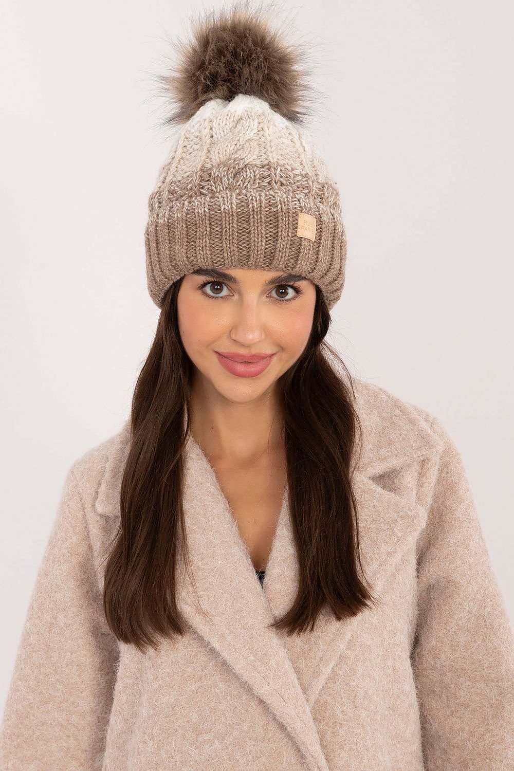 Elegant winter beanie from Rue Paris featuring a luxurious plaid pattern and fluffy pom-pom, made from a warm wool and acrylic blend.