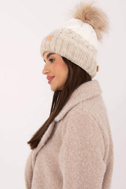 Elegant winter beanie by Rue Paris featuring a stylish plaid pattern and fluffy pom-pom for added charm, perfect for luxurious winter styling.