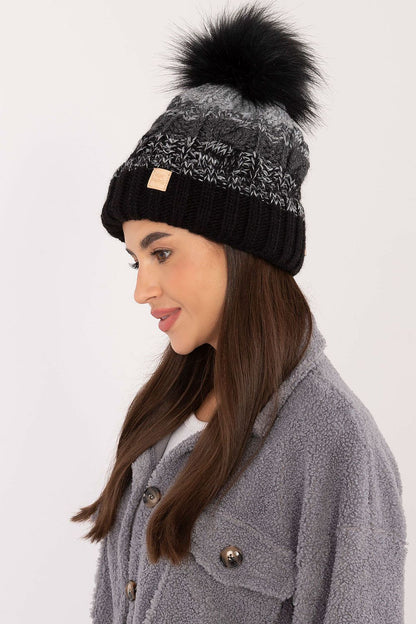Side view of the sophisticated Rue Paris winter beanie adorned with a playful pom-pom, perfect for enhancing chic winter outfits.