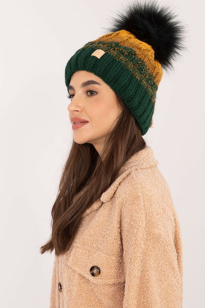 Elegant winter beanie with a stylish plaid pattern and fluffy pom-pom, crafted by Rue Paris. A luxurious blend of acrylic, polyamide, and wool ensures warmth and comfort.