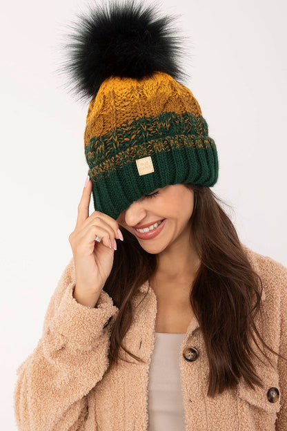 Elegant winter beanie styled with plaid pattern and pom-pom, designed by Rue Paris, perfect for adding a touch of luxury to your cold-weather outfits.