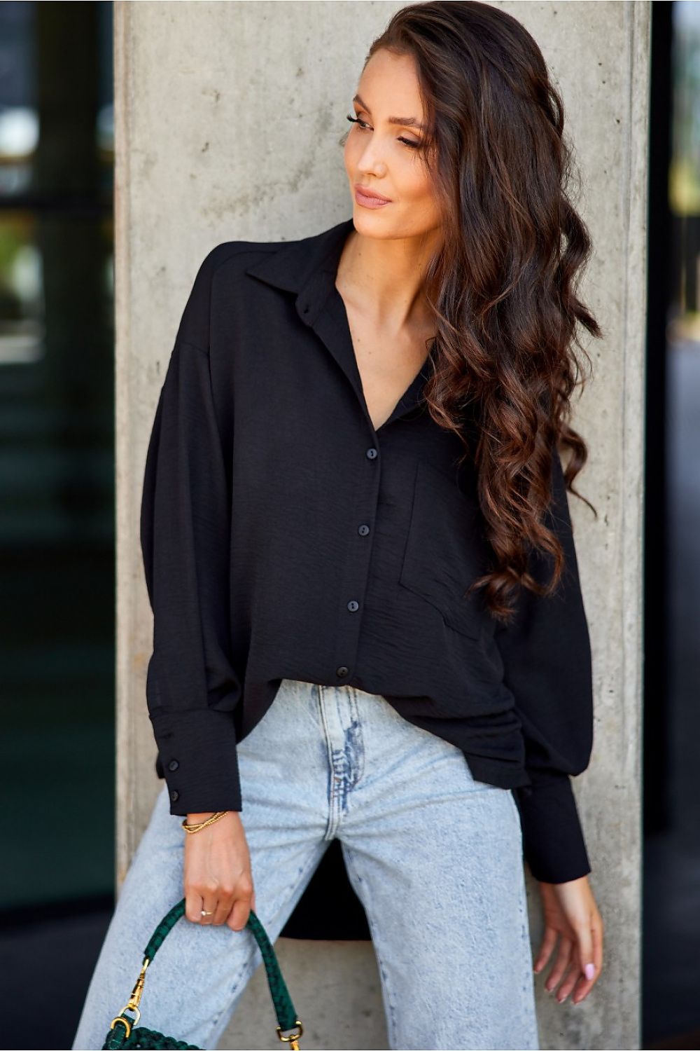 Model wearing Roco Fashion's asymmetrical oversized shirt styled with jeans for a chic casual look.