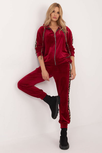 Italy Moda luxurious women's velour set presented on a model, highlighting the chic high-waisted pants and stylish blouse with animal-pattern stripes.