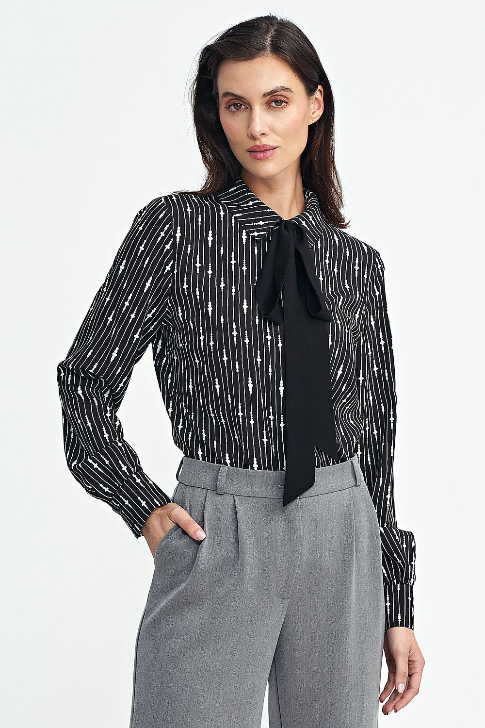 Model wearing the elegant Nife viscose shirt with long sleeves, demonstrating versatility and modern fashion in an upscale setting.