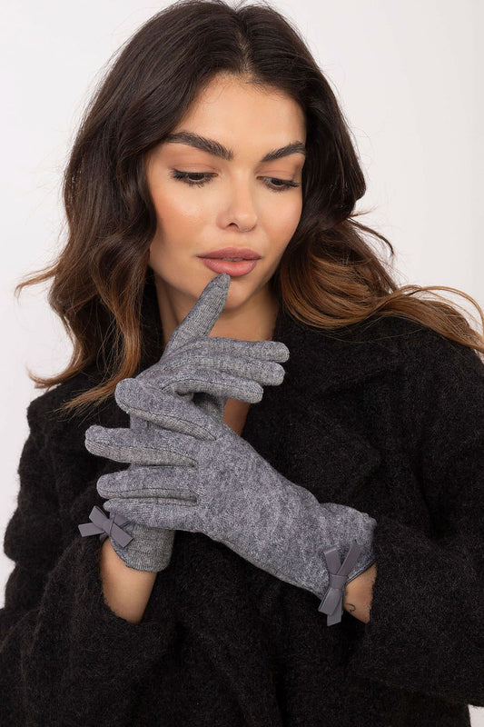 Elegant women's gloves by AT featuring decorative bows, touchscreen technology, and warm fabric, available in sizes S to L.