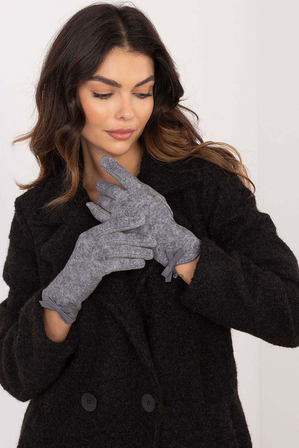 Stylish AT women's gloves showcasing decorative bows, designed for warmth and touchscreen compatibility, perfect for fashion-forward cold weather.