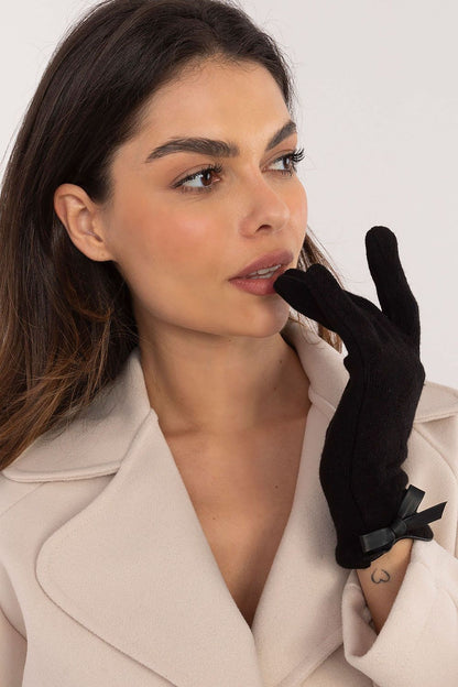 Luxury women's gloves from AT, showcasing a flattering silhouette with decorative bows, perfect for chic winter fashion.