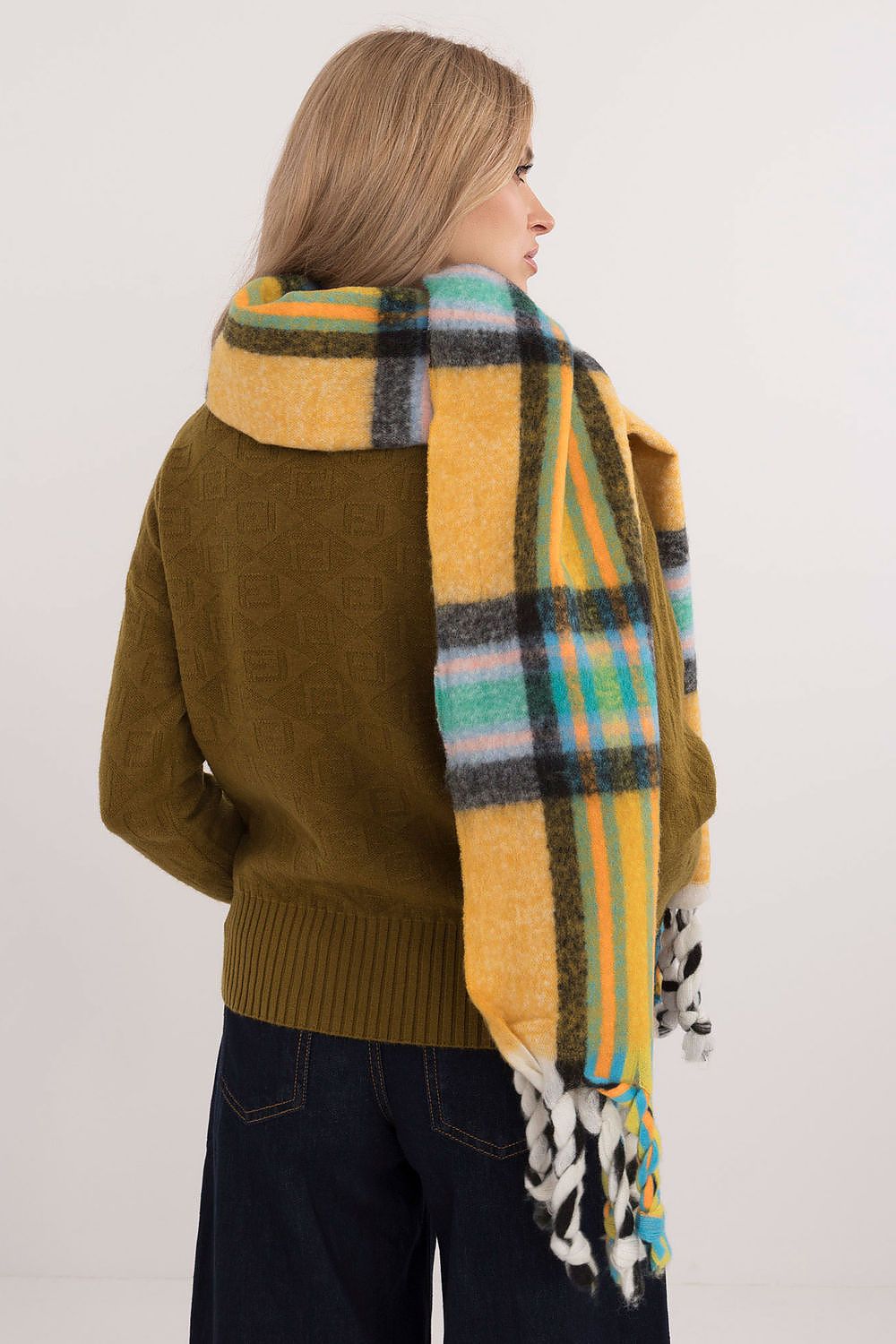 Sophisticated winter styling featuring an AT check pattern scarf with tassels, showcasing luxurious warmth and comfort.