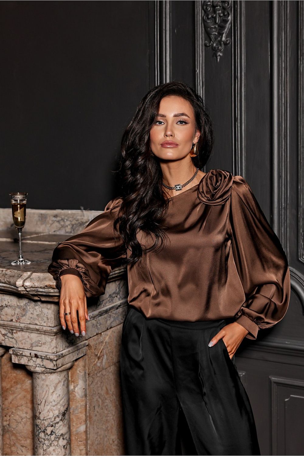 Model wearing the elegant Evelyn Satin Blouse by Roco Fashion, showcasing its stylish design and comfortable fit for a chic evening look.