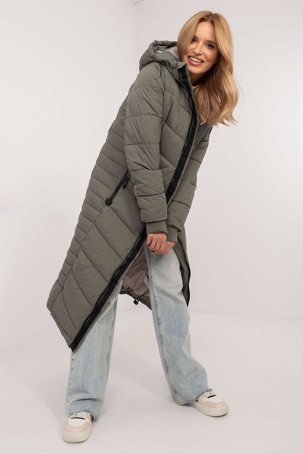 Stylish long coat by Sublevel in an autumn landscape, emphasizing its warmth, functionality, and contemporary style for chic women.