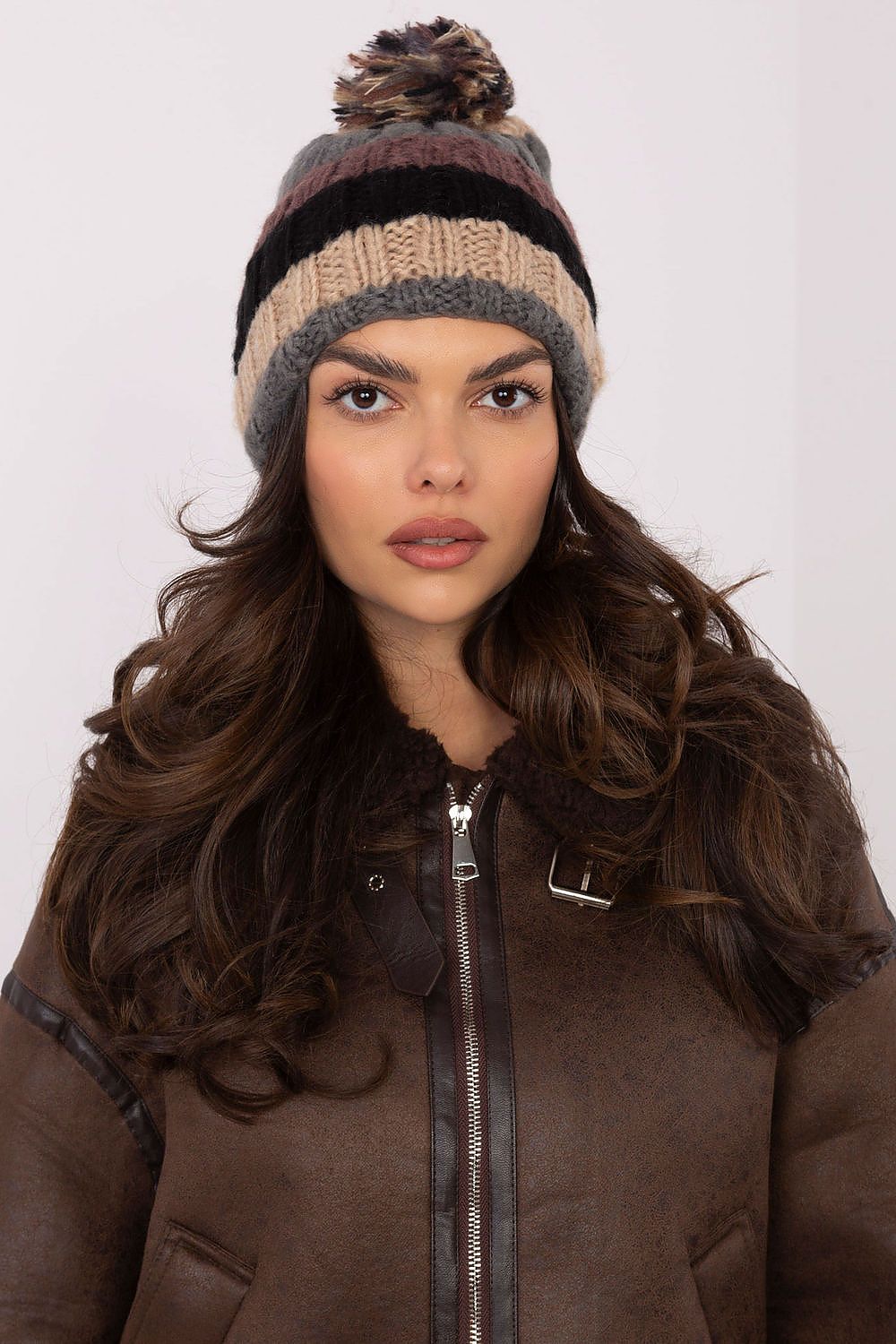 Stylish winter beanie cap by AT featuring vibrant striped design and fluffy pom-pom for chic cold-weather fashion.
