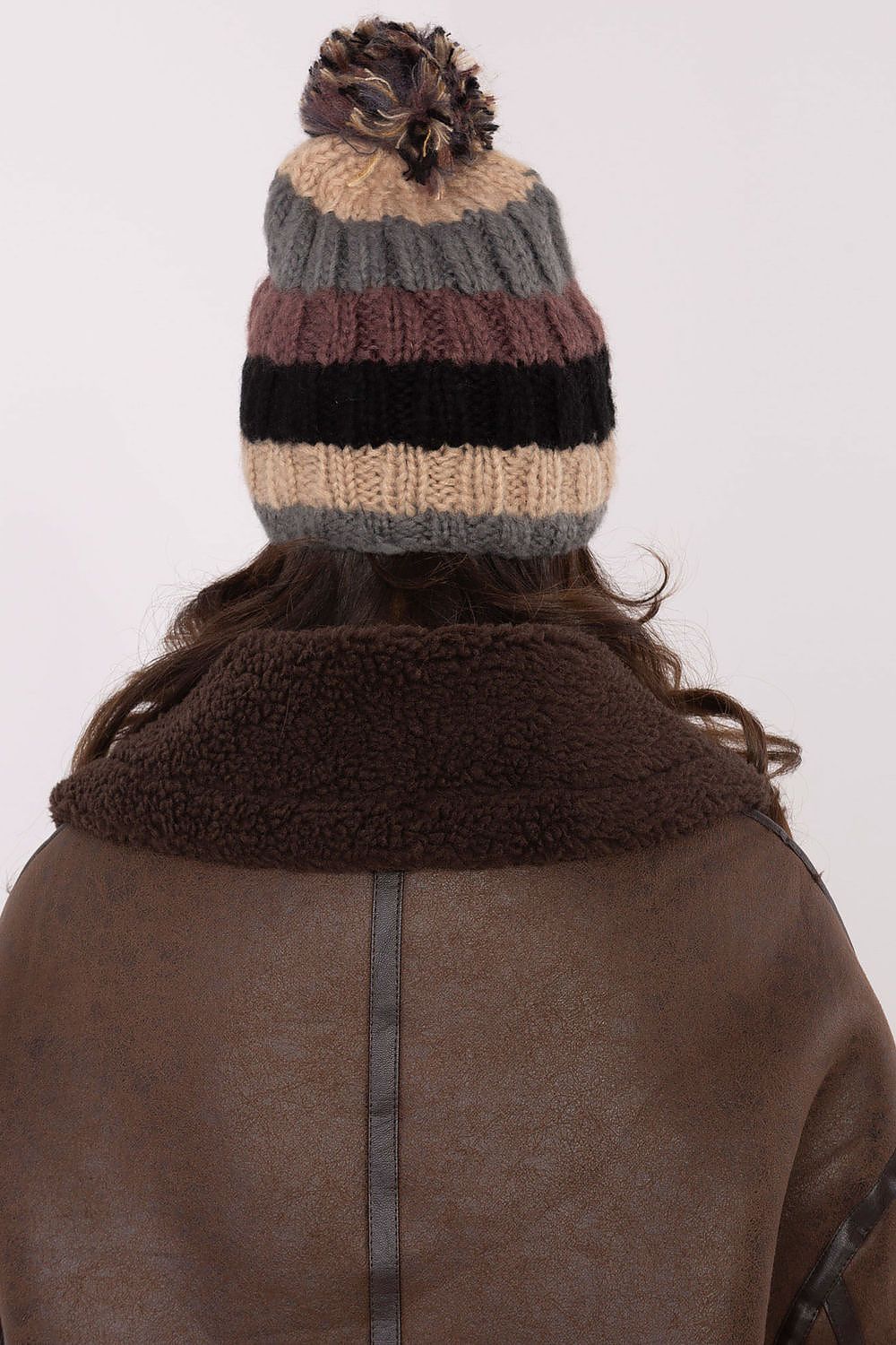 Luxurious winter beanie cap by AT featuring vibrant stripes and a fluffy pom-pom, ideal for stylish winter outings.