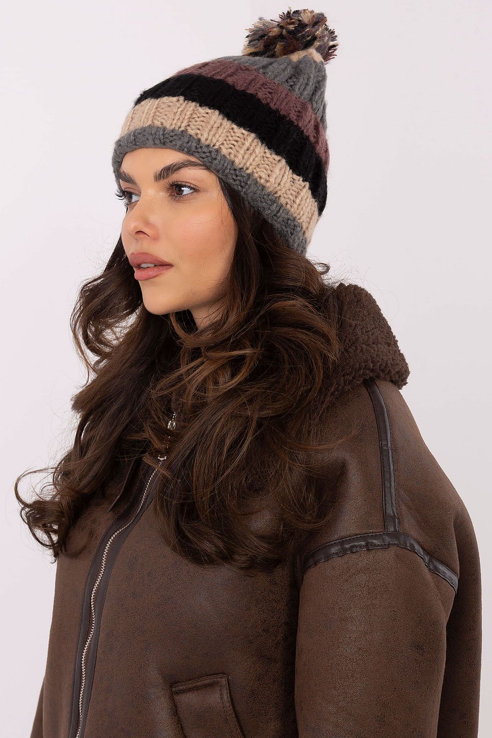 Elegant winter beanie cap with multicoloured stripes and a plush pom-pom from AT, perfect for fashionable winter wear.