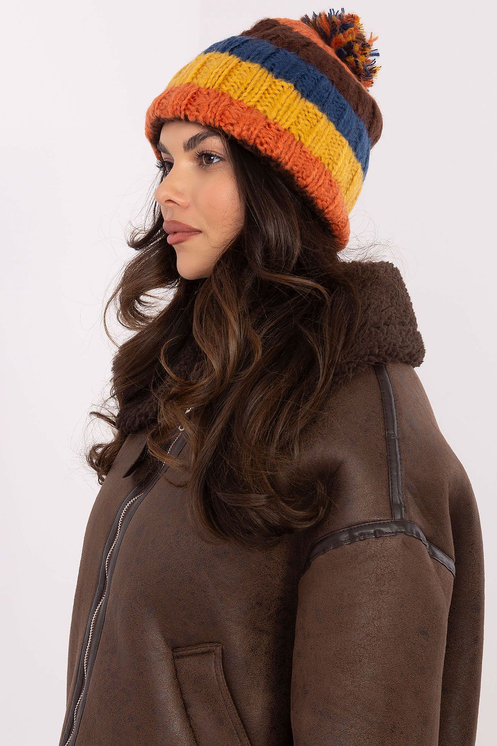 Stylish winter knit cap by AT showcasing radiant stripes and a fluffy top pom-pom for a trendy winter look.