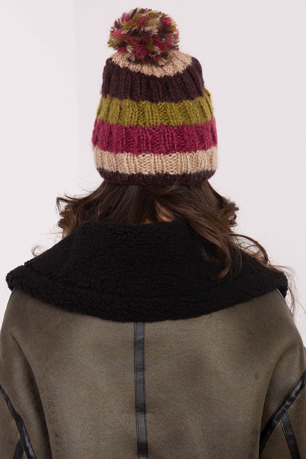 Elegant winter beanie cap by AT, adorned with cheerful vibrant stripes and a luxurious fluffy pom-pom, ideal for cold days.