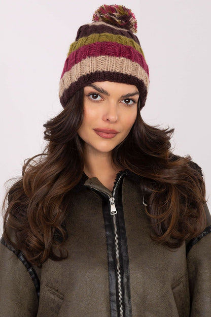 Fashionable winter beanie cap from AT, featuring eye-catching striped patterns and a plush pom-pom, perfect for stylish outdoor activities.