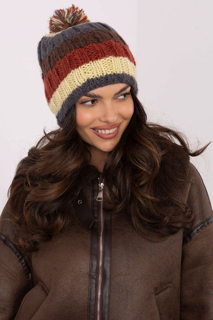 Luxurious stylish winter beanie cap by AT featuring vibrant stripes and a fluffy pom-pom, perfect for elegant winter outings.