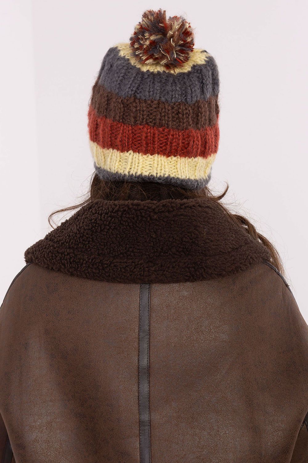 Elegant winter beanie cap by AT with eye-catching vibrant stripes and a soft pom-pom, ideal for fashion-forward individuals.