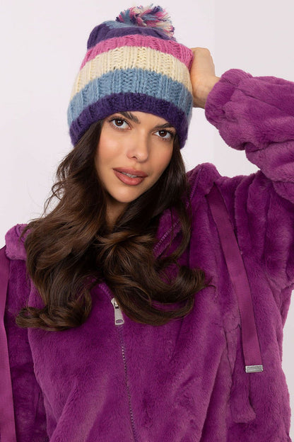 Sophisticated winter beanie from AT, adorned with vibrant stripes and a soft pom-pom, blending style and functionality.