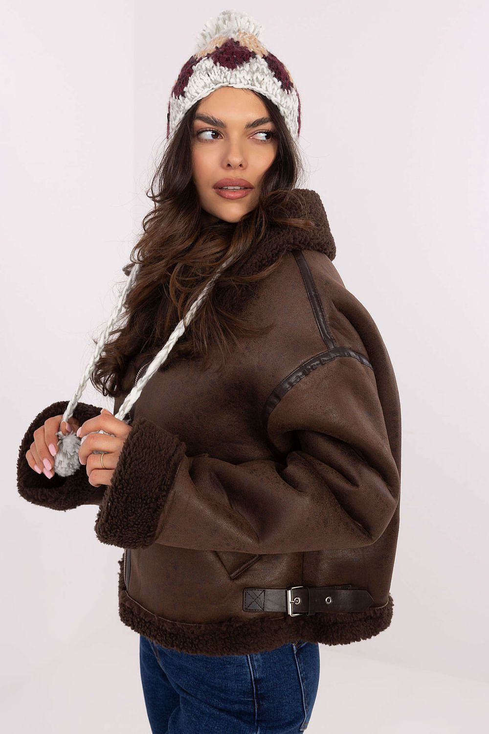 Elegant acrylic beanie with a fluffy pom-pom, designed by AT, showcasing a modern geometric diamond design.