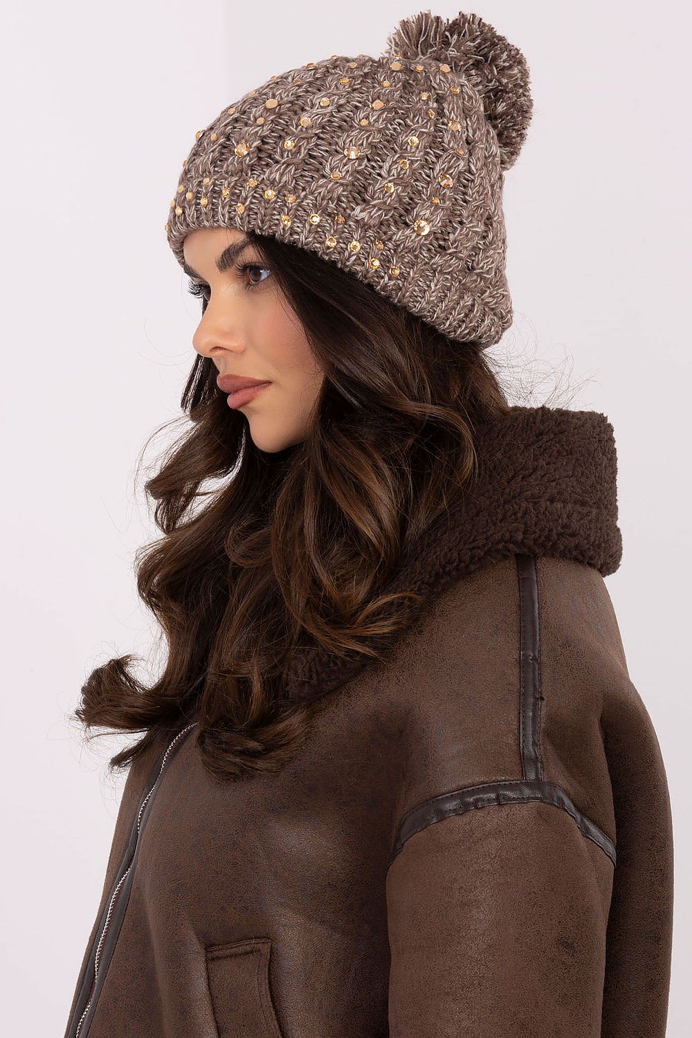 Chic women's winter beanie cap by AT featuring zircon embellishments and a fluffy pom-pom, crafted from soft acrylic for warmth and style.