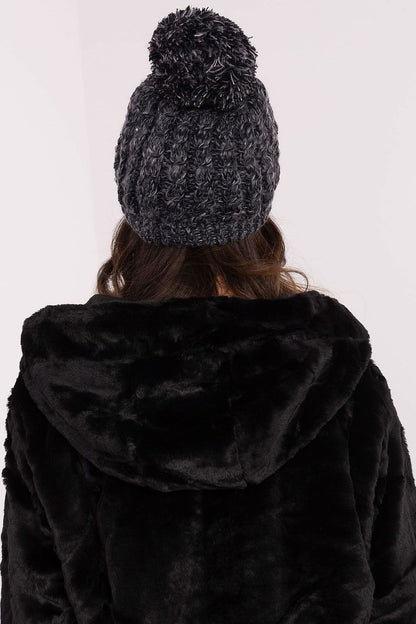 Stylish and warm women's beanie by AT, adorned with a fluffy pom-pom and elegant zircon details, ideal for both casual and formal winter occasions.