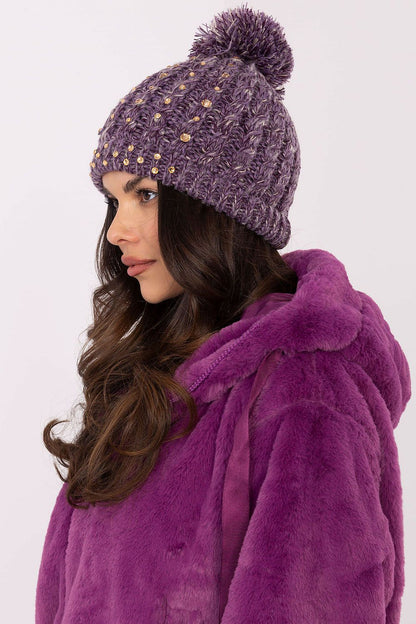 Elegant AT branded women's winter beanie cap in soft material, featuring delicate zircon accents and a fashionable fluffy pom-pom.