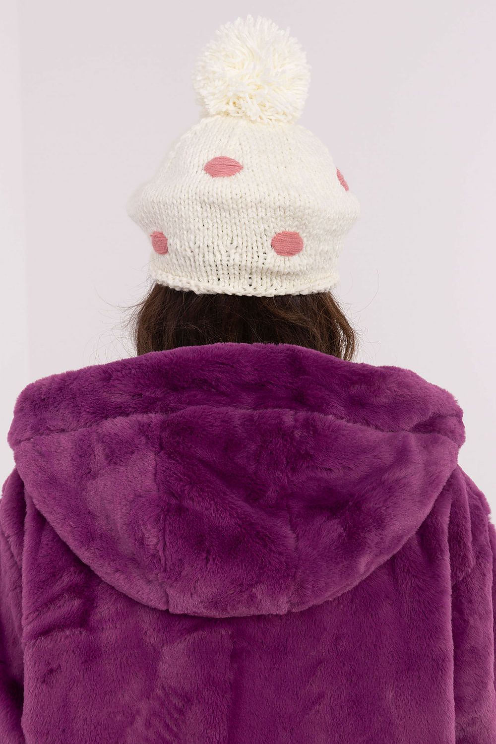 Close-up of the luxurious women's winter beanie hat by AT, showcasing an elegant design with decorative dots and a fluffy pom-pom for a sophisticated winter look.