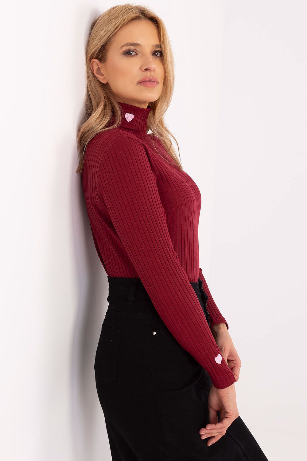 Elegant women's turtleneck sweater from Relevance displayed on a hanger, featuring a classic ribbed texture and sophisticated silhouette.