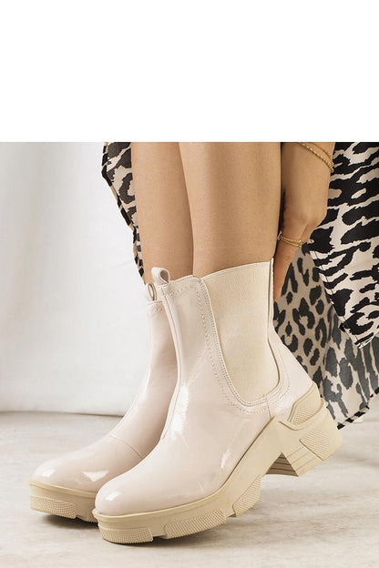 Solea luxury beige patent leather ankle boots Asma styled with a fitted skirt, highlighting versatility and comfort for sophisticated looks.