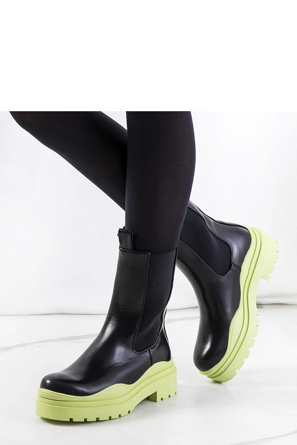 Elegant Solea black ankle boots featuring a distinctive green rubber sole, showcasing a sleek design perfect for autumn and winter fashion.