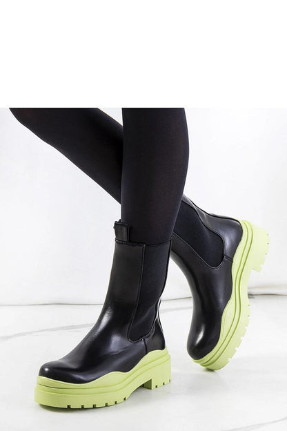 Elegant Solea black ankle boots featuring a distinctive green rubber sole, showcasing a sleek design perfect for autumn and winter fashion.