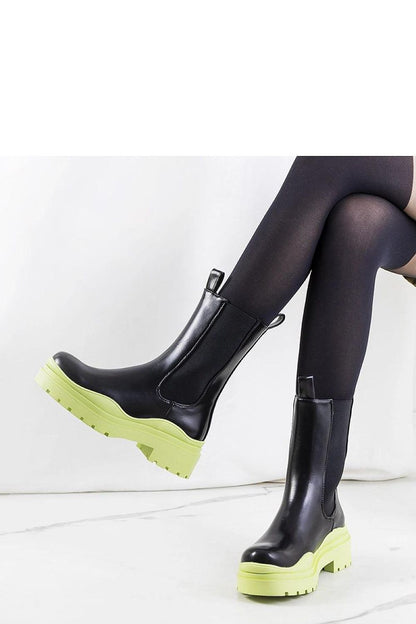 Close-up view of Solea black ankle boots with green rubber sole, highlighting the elastic inserts for a perfect fit and luxurious comfort.