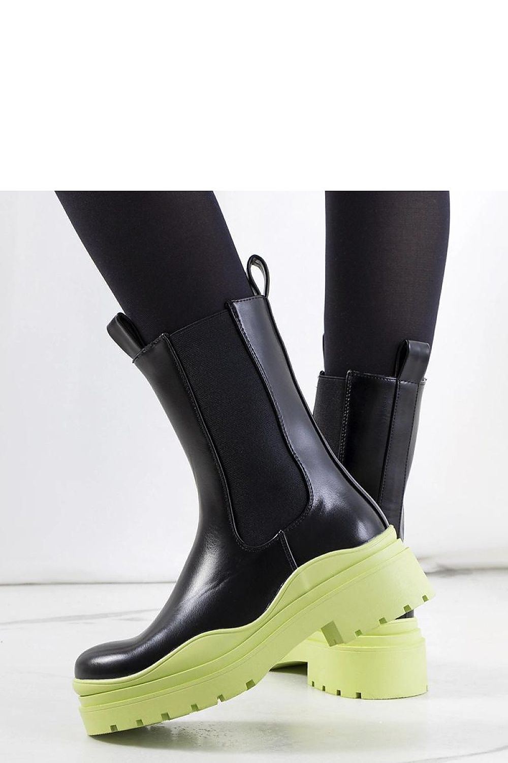 Solea luxurious black ankle boots featuring a unique green rubber sole, designed for elegance and comfort, showcasing slip-on style with elastic inserts for a perfect fit.