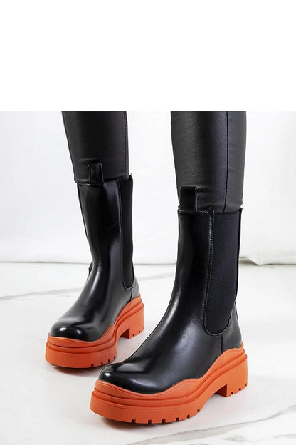 Close-up of Solea's black ankle boots with standout green high sole, highlighting the wavy shaft design that adds sophistication to your autumn wardrobe.