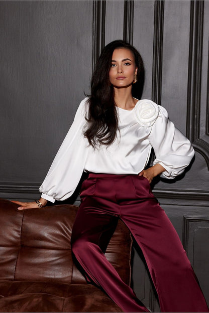 Evelyn Satin Blouse With Rose Detail from Roco Fashion, elegantly showcasing its puffy sleeves and luxurious satin finish.