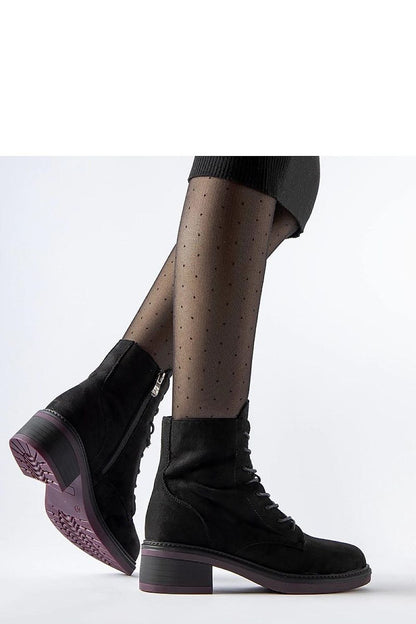 Close-up of Solea black ankle boots showcasing the high-quality synthetic leather exterior, stylish purple sole, and convenient zip closure for chic winter footwear.