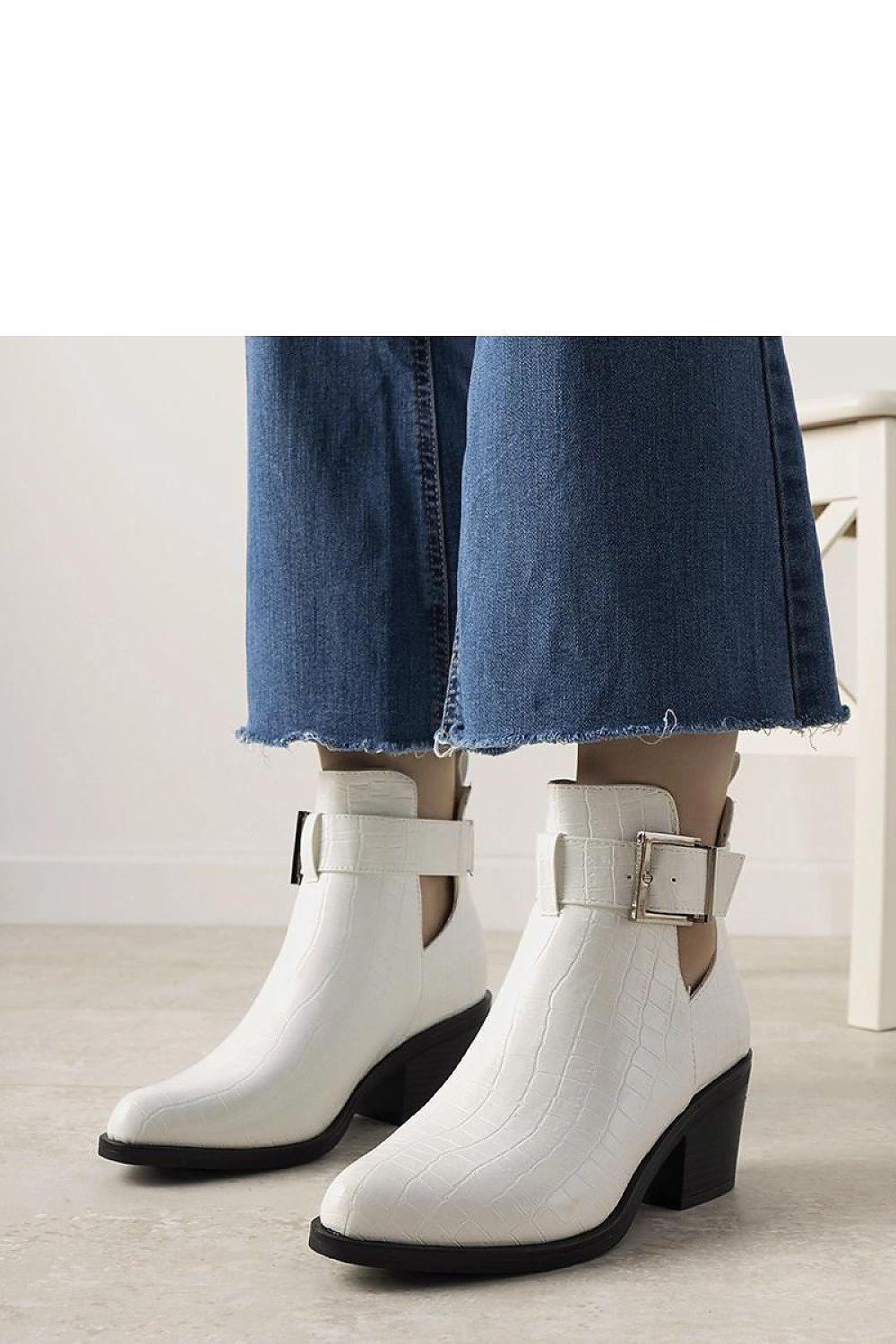 Solea's stylish white ankle boots with adjustable ankle strap and modern cutout detailing for a chic look.