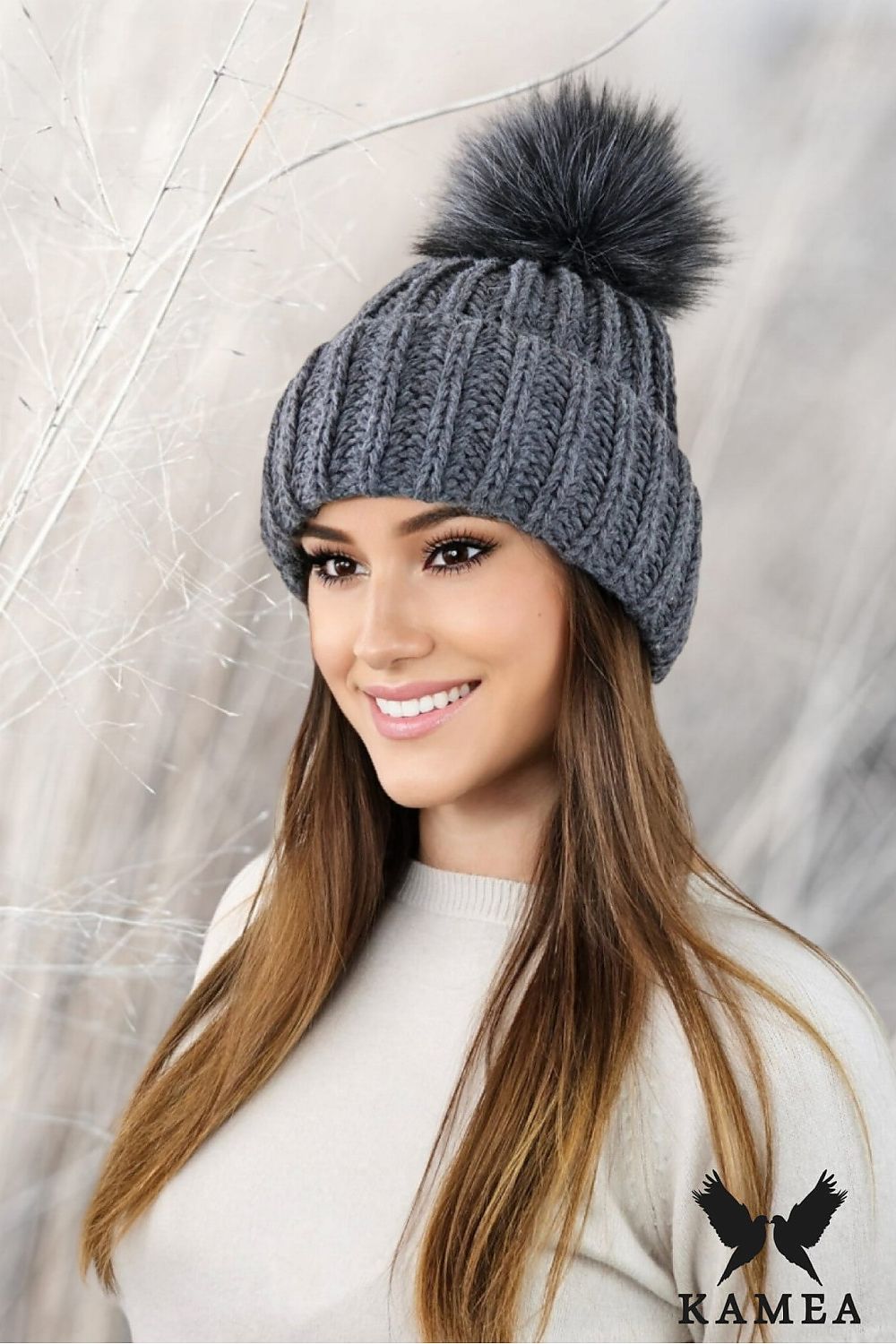 Stylish Kamea Nerea winter hat with a playful eco-friendly pompom and elegant leather logo patch, perfect for winter fashion.
