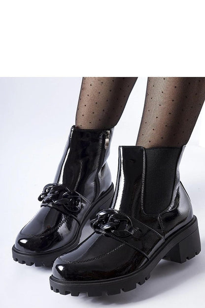 Solea patent leather boots in black, highlighting a modern aesthetic with metal detailing, perfect for chic outfits.