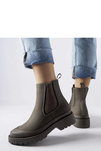 Solea green women's boots displayed on a rustic background, highlighting their chic design and winter suitability, ideal for adding a touch of luxury to any wardrobe.